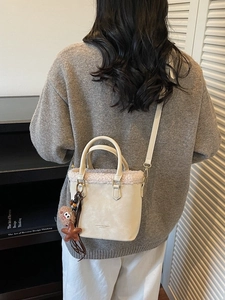 Sac seau rétro en cuir beige avec empiècements en peluche, pendentif étoile et breloque