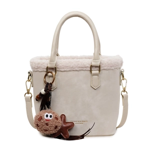 Cream suede shoulder bag with faux fur trim and cute charms for winter fashion