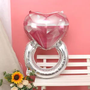 Pink heart-shaped diamond ring foil balloon on a bench for wedding or proposal decor