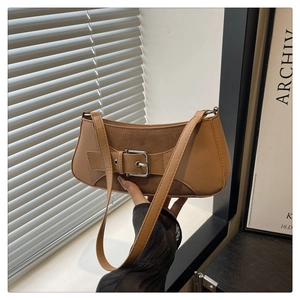 Primer plano del bolso baguette de patchwork marrón con hebilla plateada y correa