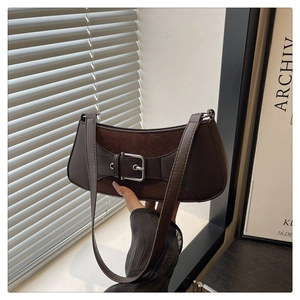 Detalle del bolso de hombro retro marrón oscuro con hebilla de metal grande y cuero rugoso