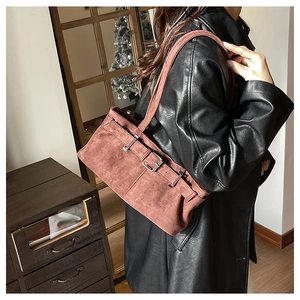 Vue latérale du sac bandoulière en suédine rouge brique avec boucle argentée