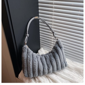 Détail d'un sac à bandoulière gris en peluche avec rayures verticales et accents dorés