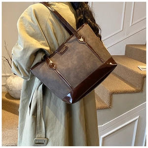 Detailed close-up of a vintage tote bag with cat pattern embossing and glossy leather straps