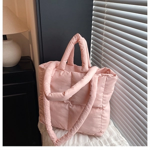 Detail of pink quilted tote bag showing plush padded texture and wide shoulder strap