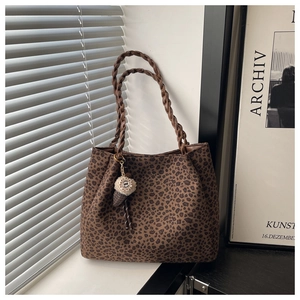 Detail of leopard print tote bag with woven rope handles and plush ice cream charm