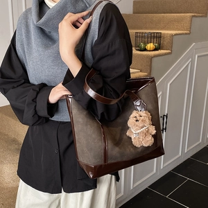 Retro coffee brown tote bag with cat pattern engraving and plush bear pendant detail