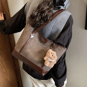Vintage brown leather tote bag with pattern, worn by model for commuting style