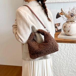 Brown teddy fleece shoulder bag with leather strap and silver hardware on a model