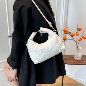 Plush faux shearling hobo bag with silver hardware and adjustable strap on a model
