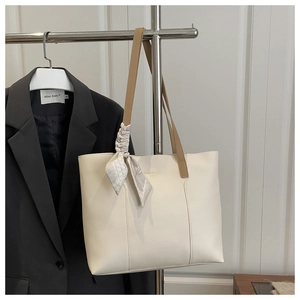 Détail du sac cabas en cuir blanc cassé avec foulard en soie et anses marron long