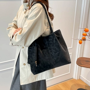 Large black frosted suede tote bag with matching pouch shown on shoulder in a lifestyle setting