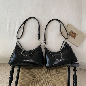 Détail de sacs en cuir PU noir brillant avec chaîne argentée et bandoulière réglable