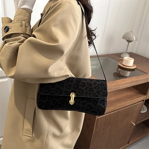 Borsa sottobraccio leopardata con fibbia dorata su un classico trench color kaki