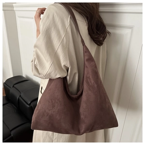 Detail of soft coffee suede shoulder bag on model with vintage hobo minimalist design