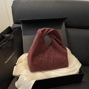 Chic leopard print velvet tote bag in burgundy with twisted handle on elegant gift setting