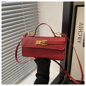 Vue détaillée du sac en cuir rouge avec texture grainée et boucle en métal doré