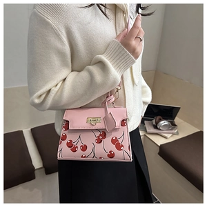 Borsa tote rosa con stampa di ciliegie e chiusura dorata mostrata in stile casual