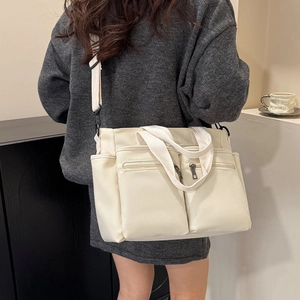 Large off-white canvas tote bag with multiple pockets and wide shoulder strap