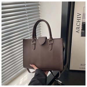 Detail view of coffee brown tote bag with pebble leather texture and gold hardware clasp