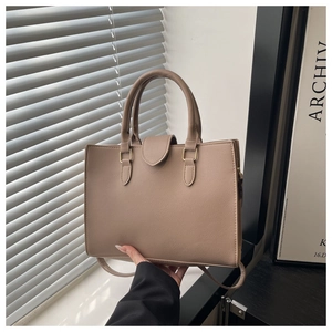 Detail of taupe tote bag showing lychee grain leather texture and gold hardware