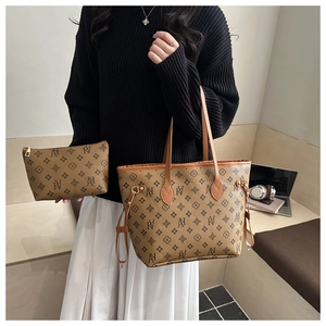 Detailed view of monogram tote bag and matching pouch held by model in natural lighting