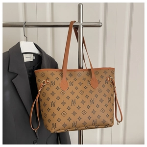 Detail of classic brown monogram tote bag with leather texture hanging on a display