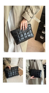 Dettaglio della borsa a mano trapuntata nera con texture morbida e design imbottito puffer