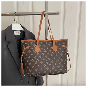 Detail view of large brown monogram tote bag with adjustable side drawstrings and top handles