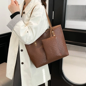Grande borsa tote marrone con trama intrecciata e pochette mostrata su modella