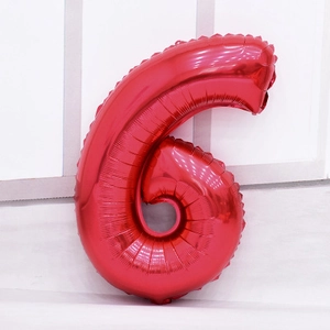 Détail d'un ballon en aluminium rouge vif en forme de chiffre 6 au fini métallique brillant
