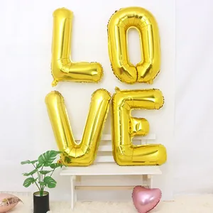 Detail of metallic gold LOVE foil balloon set with a pink heart for wedding party decor