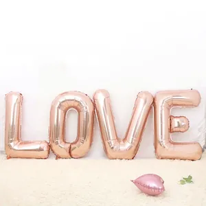 Detail of rose gold LOVE letter and heart foil balloons on a white plush carpet