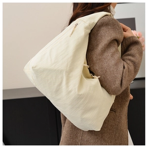 Nylon tote bag worn with a brown blazer, showing large capacity and comfortable strap