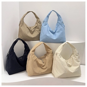 Multiple colors of large capacity nylon tote bags displayed on white pedestals