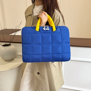 Quilted royal blue document bag with bright yellow handles and puffer style design