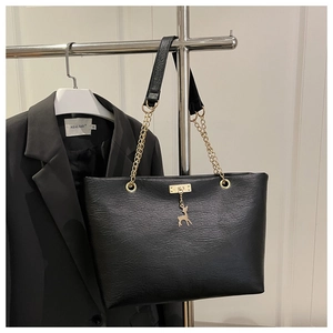 Détail du sac fourre-tout noir avec pendentif cerf doré et bandoulière en chaîne