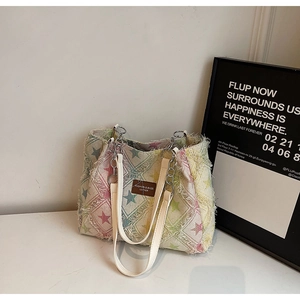 Distressed denim tote bag with colorful star patches and fringe edges for women