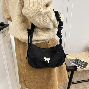 Sac hobo noir chic avec papillon et bandoulière froncée, porté par un modèle