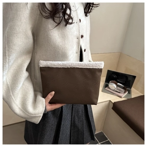 Dettaglio borsa tote marrone scuro con bordo in montone bianco e similpelle di alta qualità