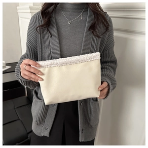 Detail van de crème lederen clutch met zachte rand van imitatiebont voor dames