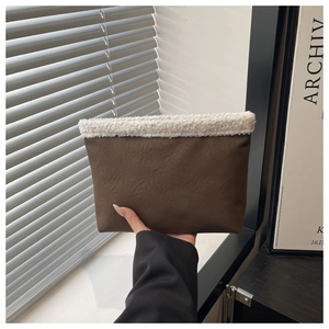 Dettaglio borsa pochette in pelle scamosciata marrone con bordo in agnellino