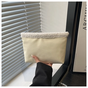 Dettaglio della borsa tote crema con bordo in shearling bianco e finitura in ecopelle opaca