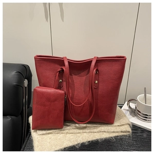 Detalle del conjunto de bolso tote rojo oscuro en cuero sintético con textura de grano