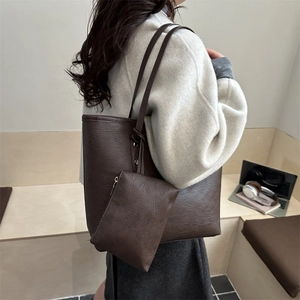 Bolso tote grande de cuero marrón con estuche a juego mostrado en una modelo
