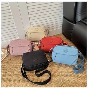 Selection of lightweight multi-colored nylon crossbody bags in soft home environment