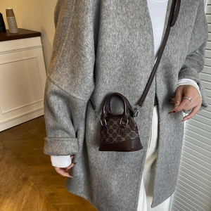 Vintage checkered mini shell bag in dark brown leather worn as a stylish crossbody purse