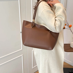 Minimalist brown leather tote bag for women shown with an autumn-inspired wool coat outfit