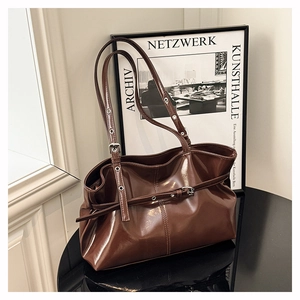 Dettaglio borsa tote marrone scuro lucida con fibbie argento e trama in pelle lucida