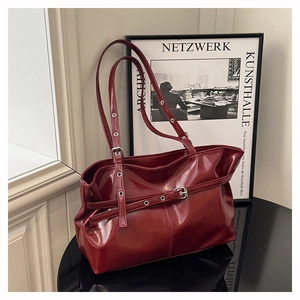 Dettaglio borsa tote bordeaux lucida con sottili cinturini decorativi e fibbie